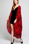 Model wearing long black crepe kimono with red leaf prints facing left